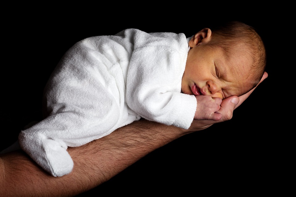 младенец лежит в руке отца 