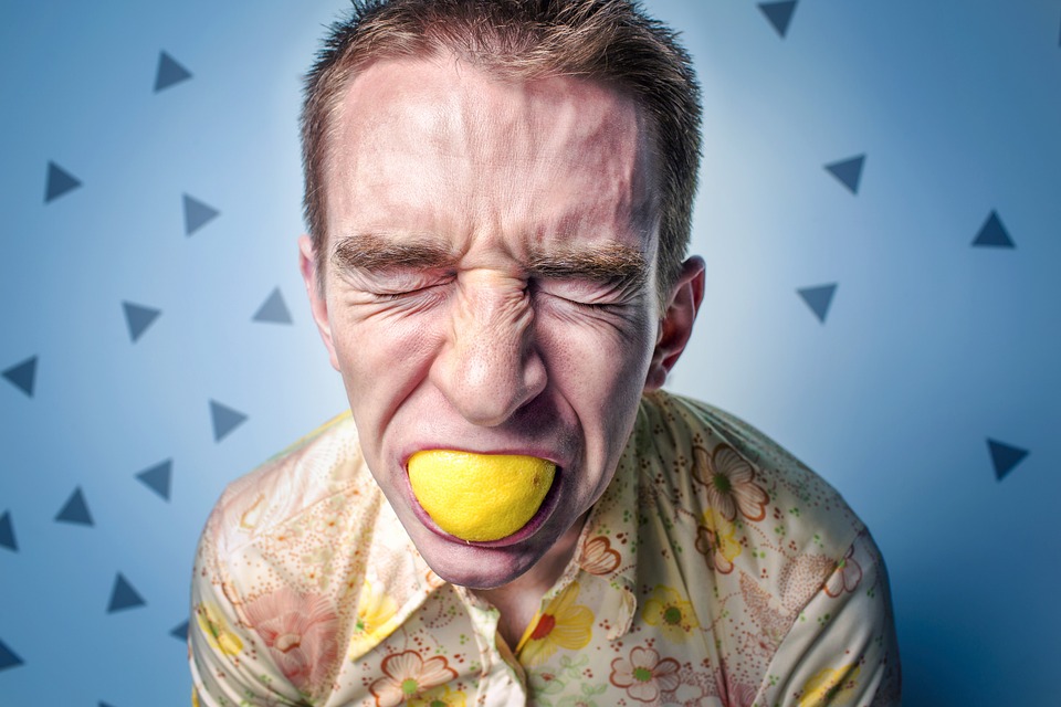 мужчина держит лимон во рту