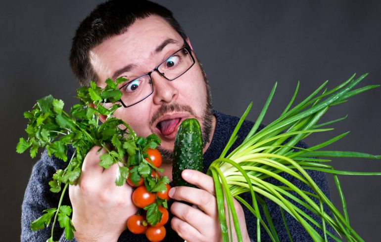 свежие овощи и фрукты кушает мужчина