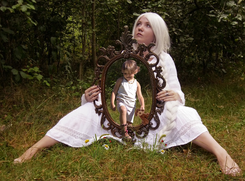 девочка в лесу держит зеркало