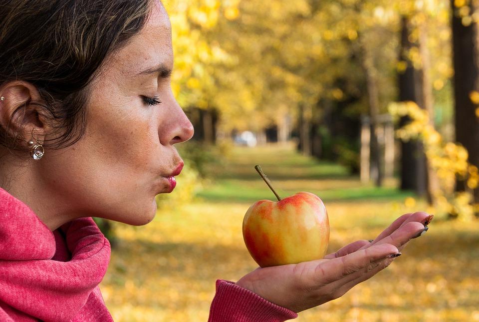 женщина держит яблоко